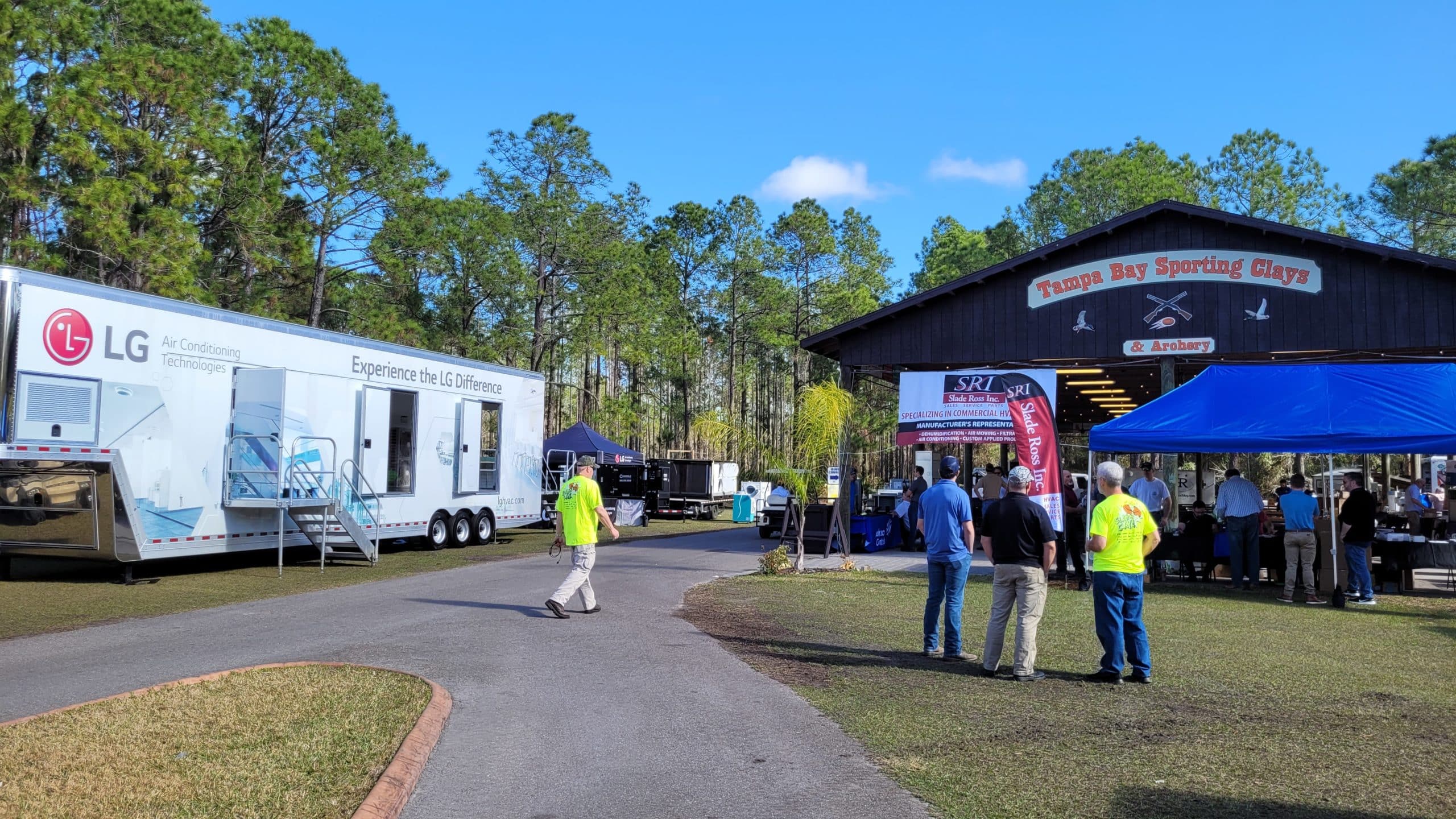 Large white LG trailer parked near a blue mobile stage