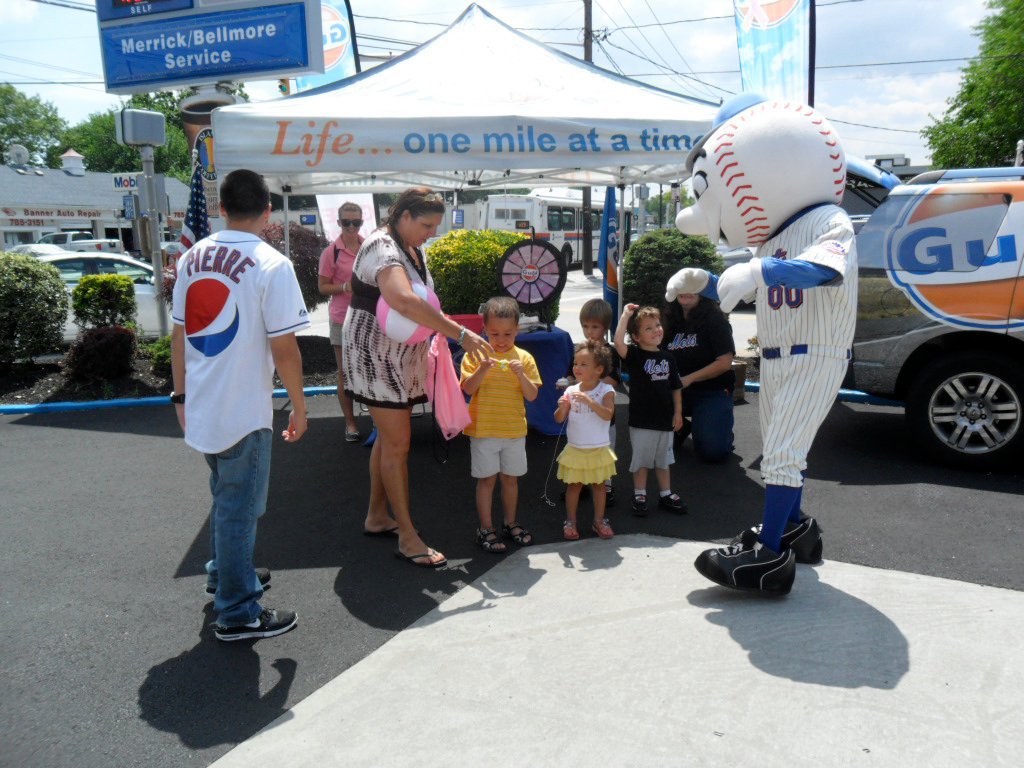 People at Gulf Oil tent with a mascot
