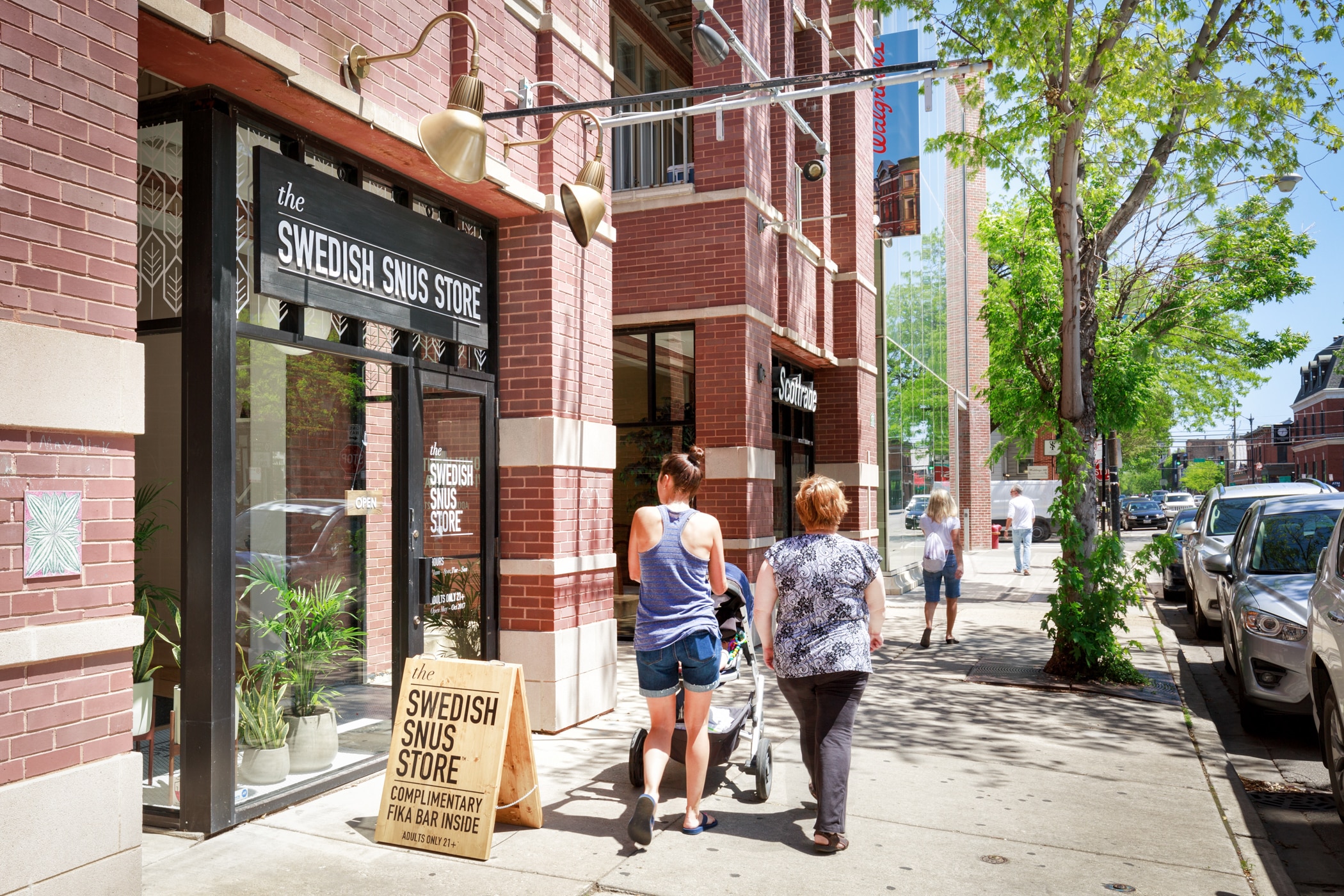 Two individuals walking outside a store building