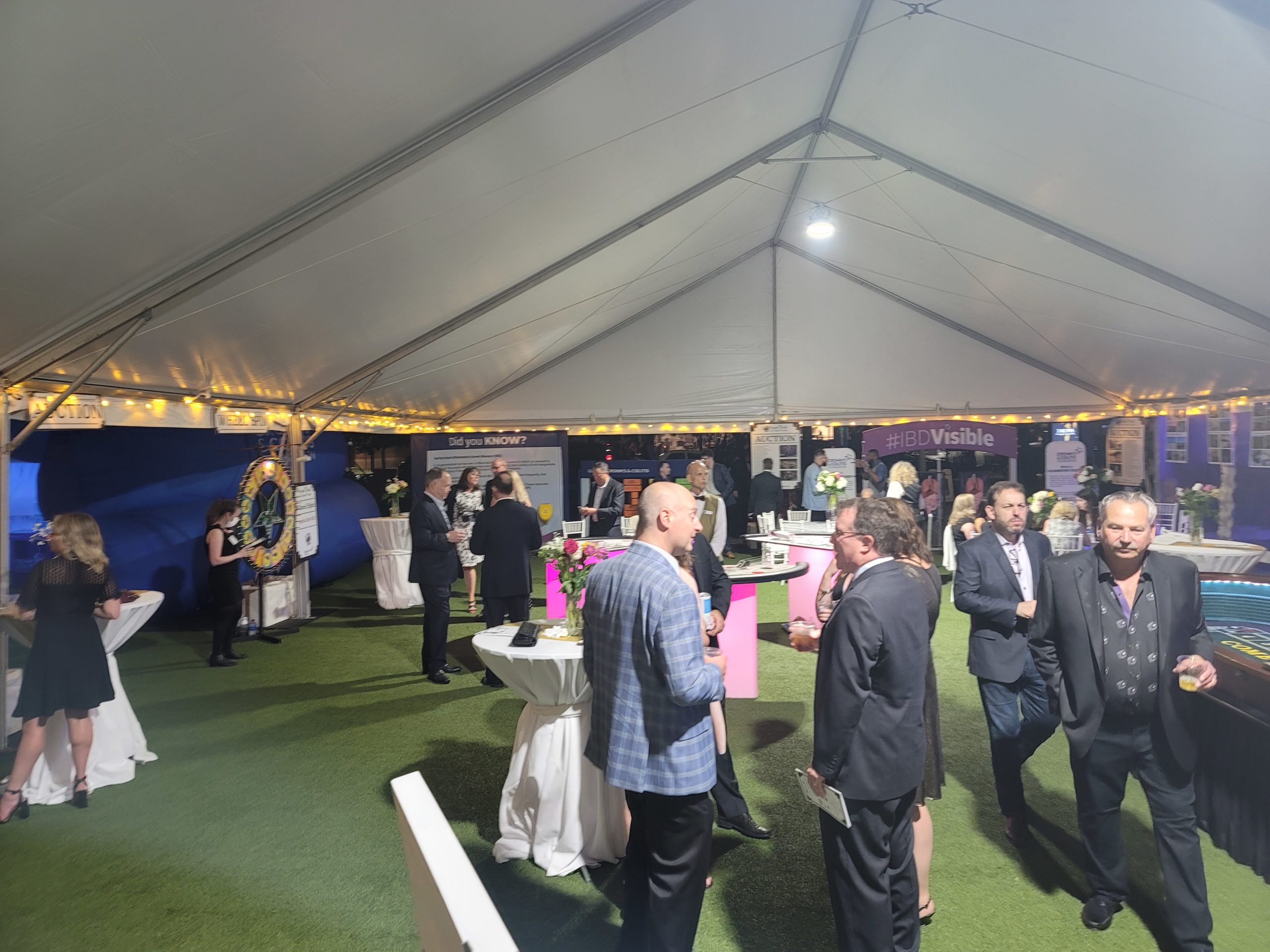 People gathered at Crohn's and Colitis exhibits under a white tent