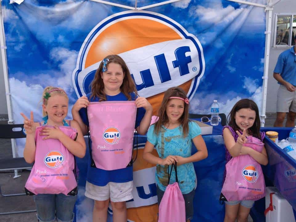 Children posing with Gulf Oil banner