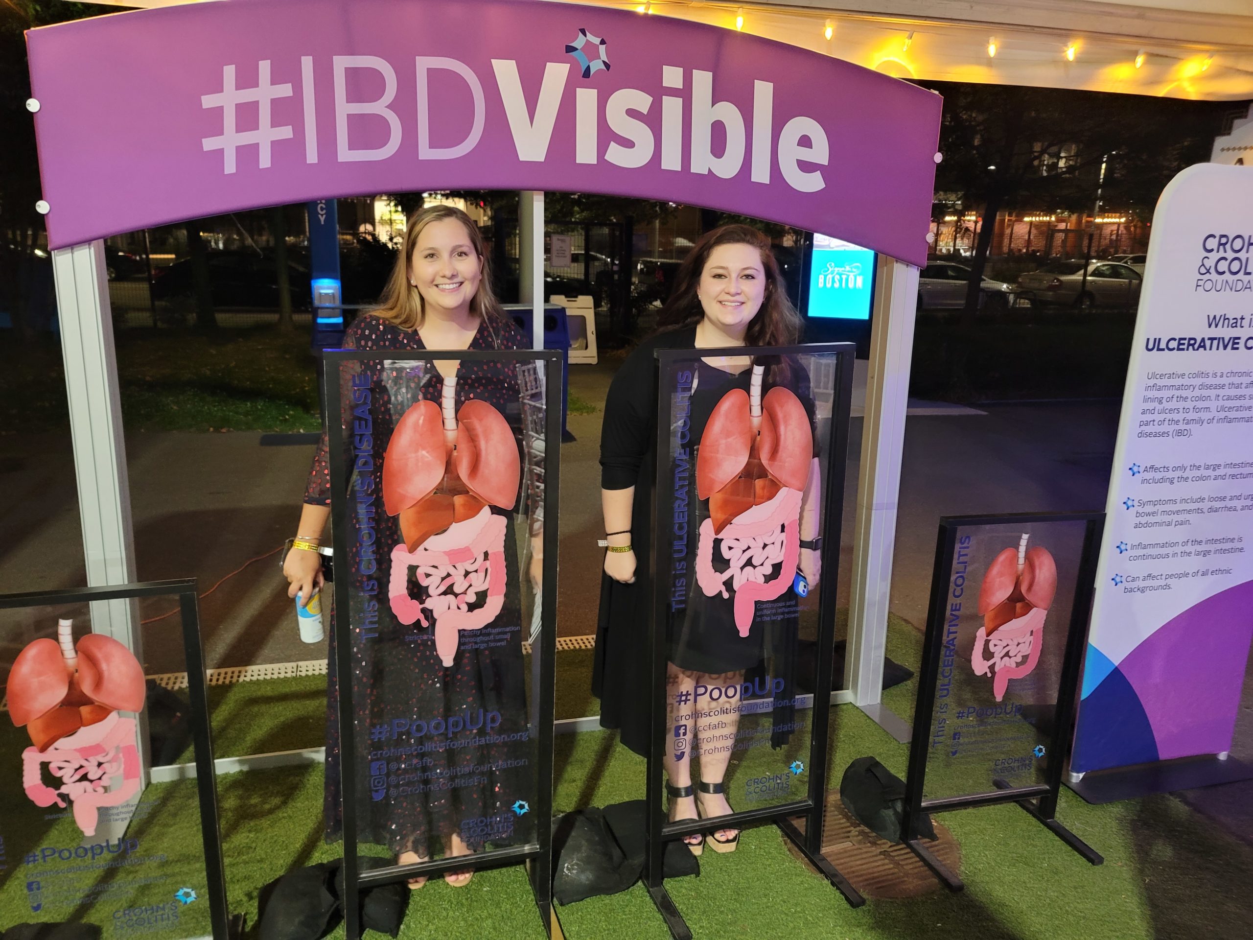 Two women posing with #IBDVisible display
