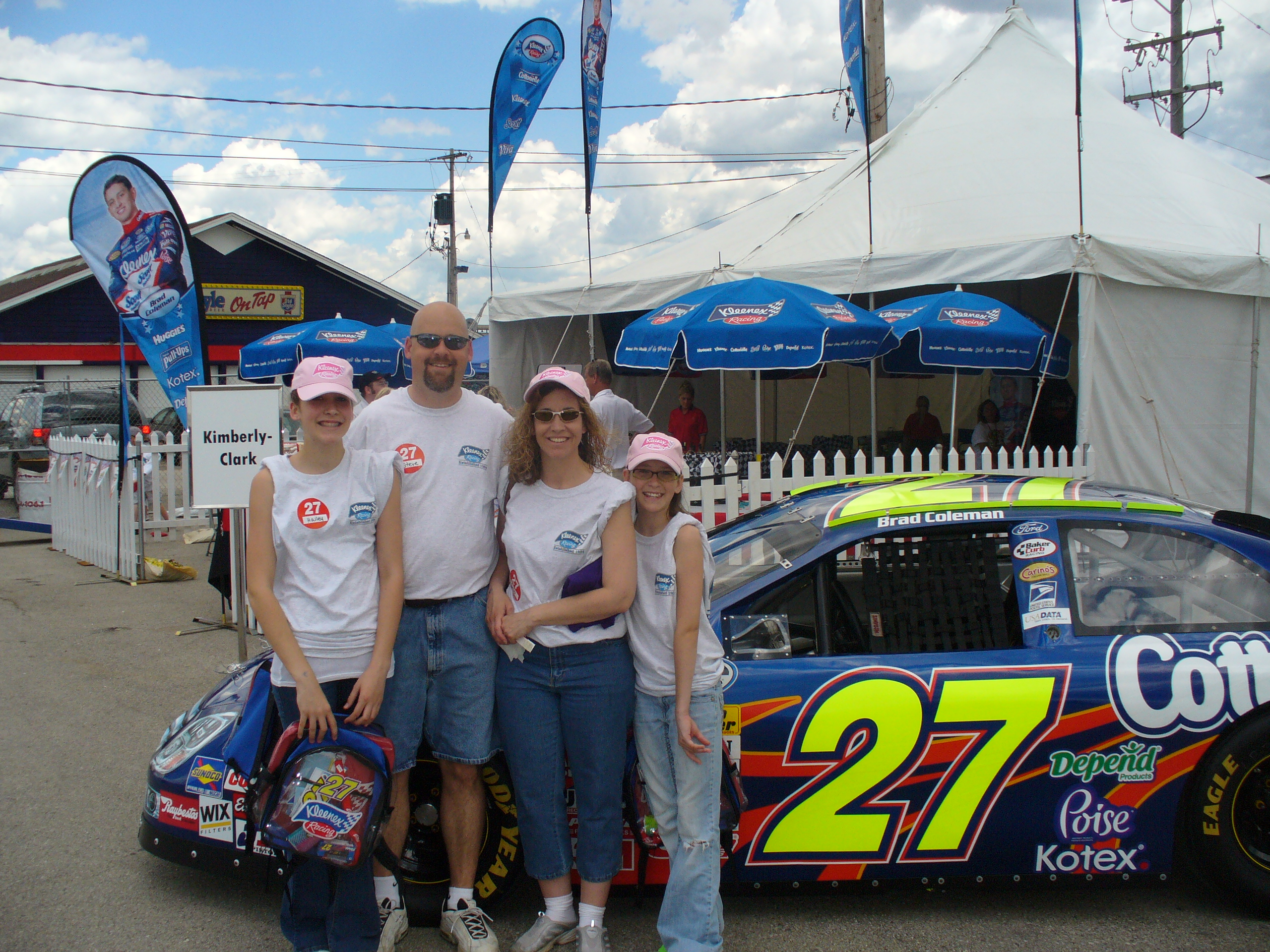 Family posing with a race car