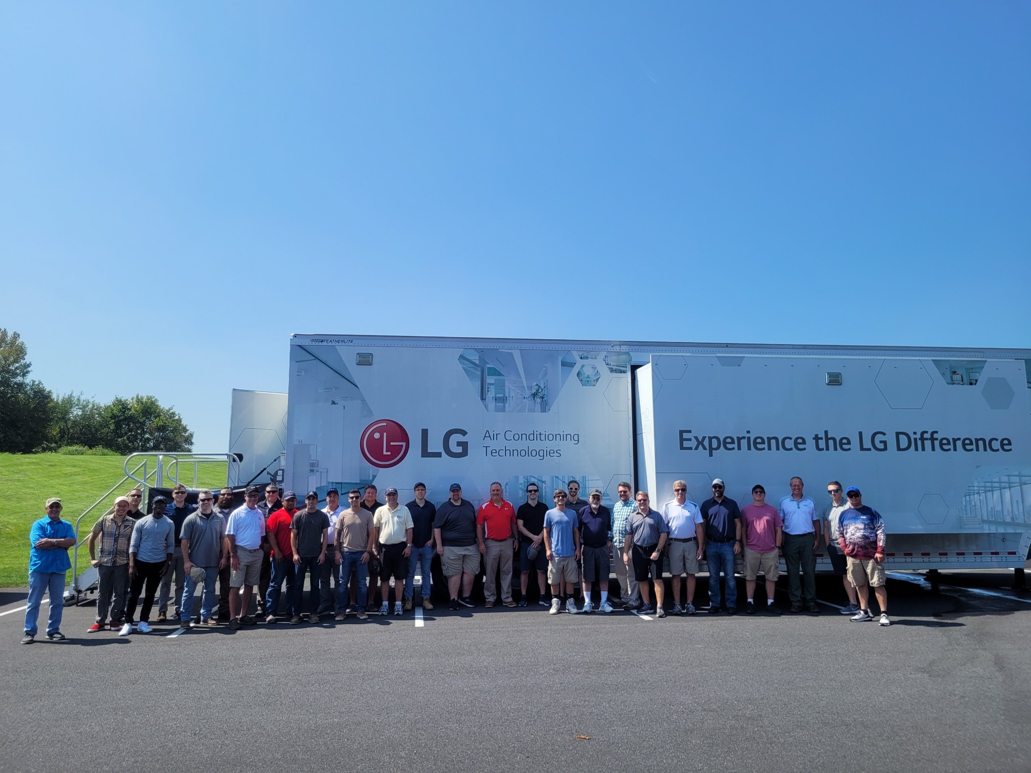 Group of people posing with LG mobile trailer