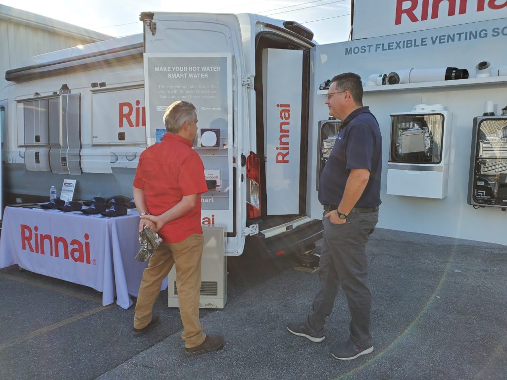 Two men standing near a Rinnai van