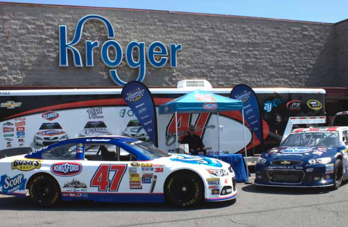 Two race cars in front of Kroger