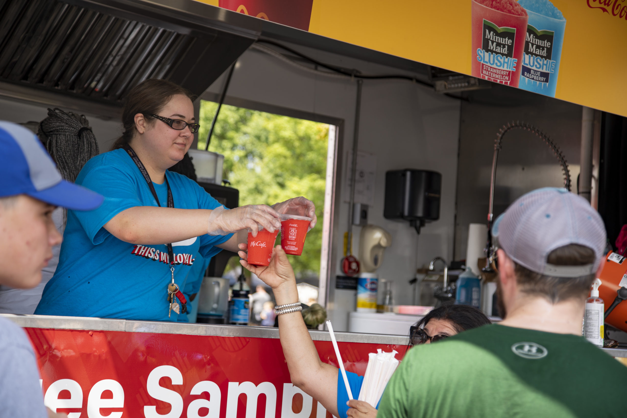 Woman in snack truck passing drinks to customers