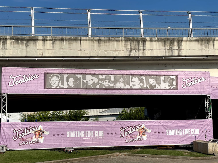 Pink Toostsies banners under a bridge