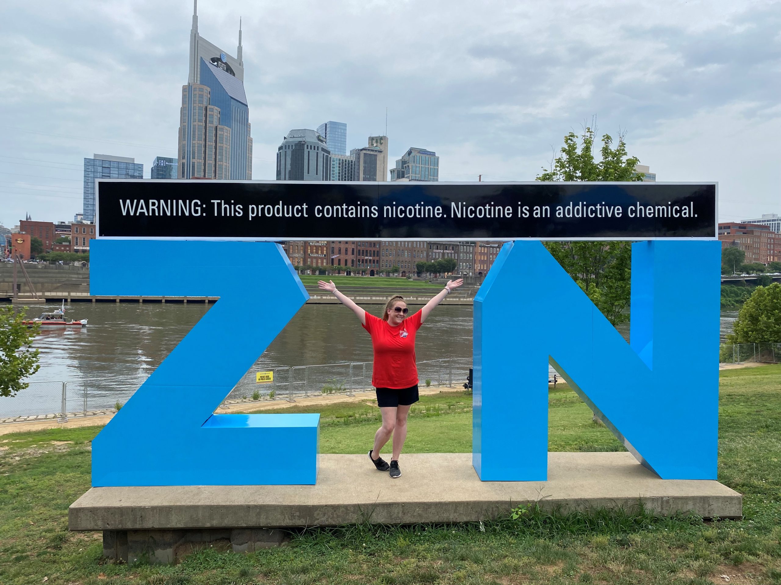 Woman posing as the letter 'Y' in ZYN sign