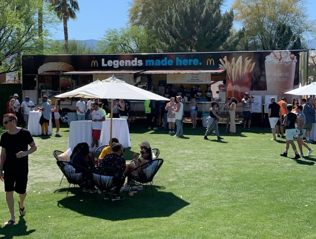 People enjoying outdoor dining at a Mc Donalds food truck by Brewco Marketing Group at a music festival.
