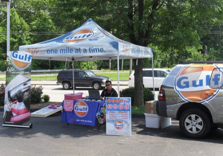 A man sitting under a Gulf Oil tent