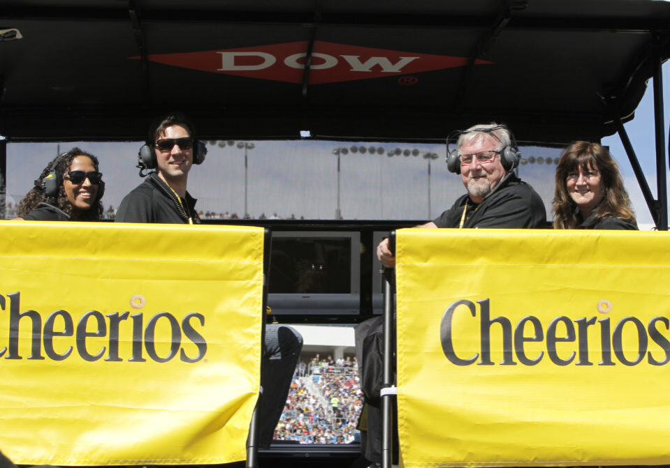 people posing for a photo behind Cheerios banners