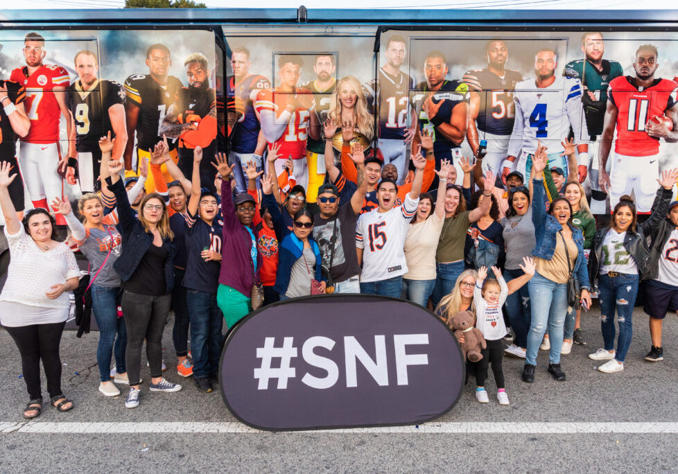 Group of people posing with Sunday Night Football sign